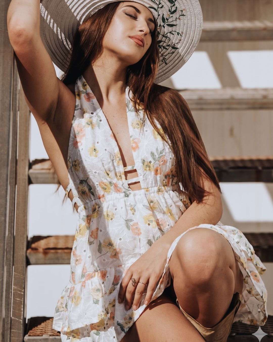 Vestido corto artesanal blanco bordado en exteriores con sombrero de paja.