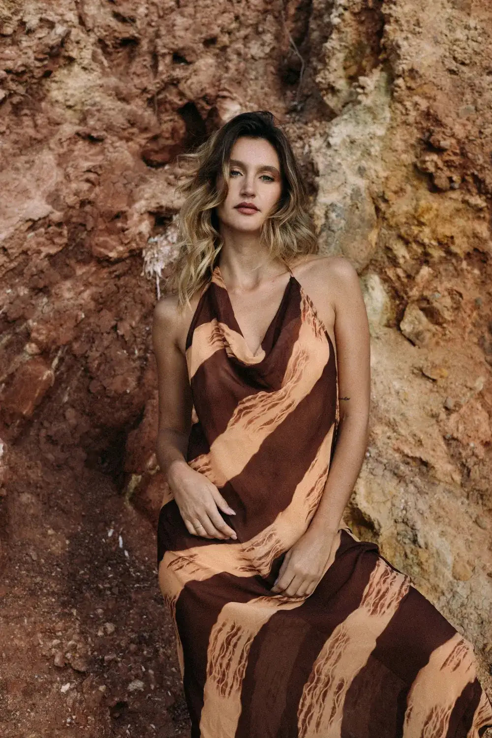 Modelo luciendo el vestido de gasa Tierra Viva en un entorno natural, con tonos tierra y estilo elegante.