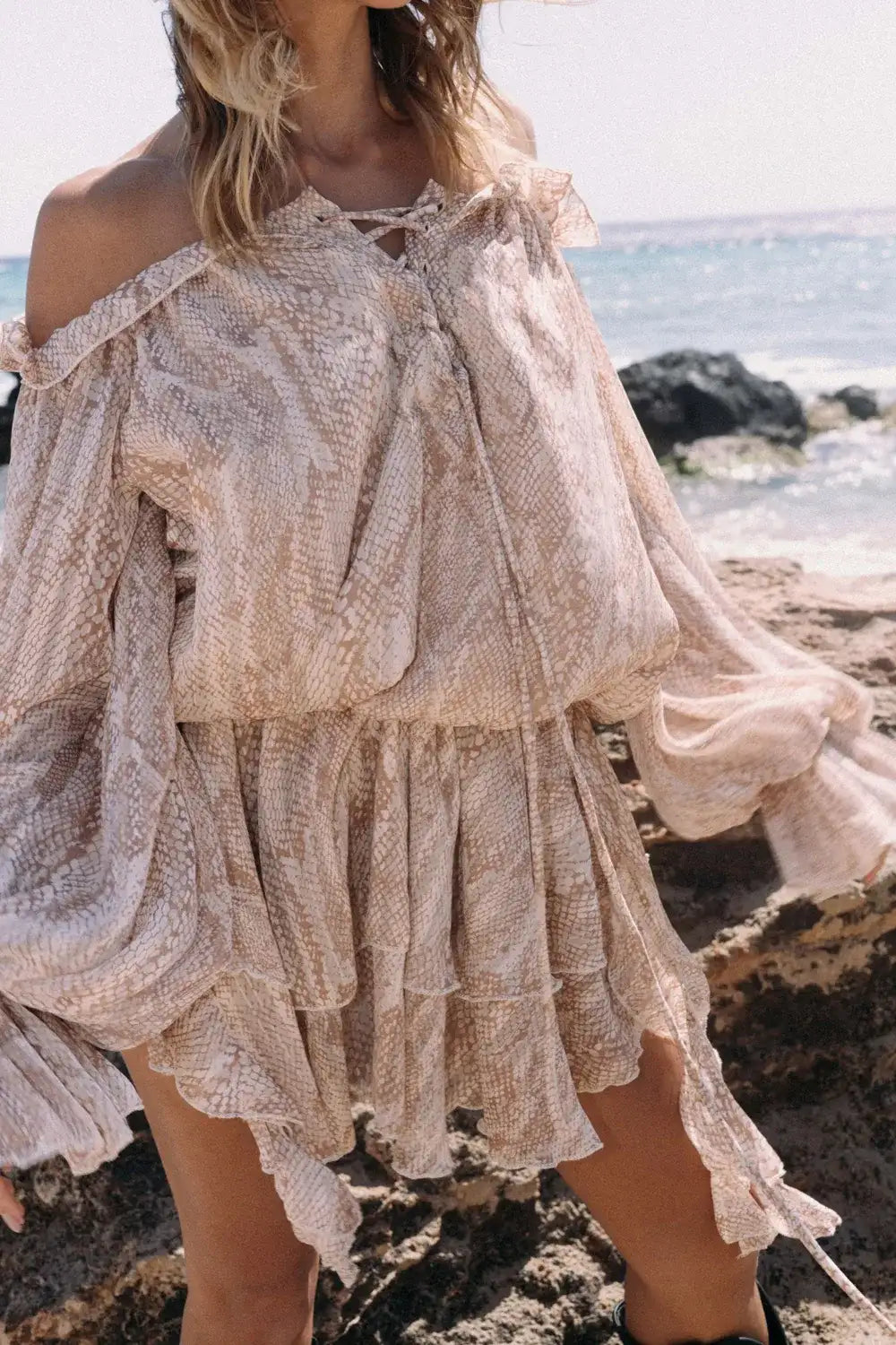 Vestido bohemio gasa ligera Brisa de Duna en un entorno costero, con estampado que evoca texturas de arena.